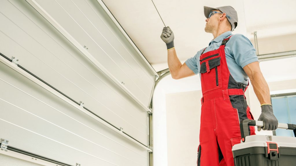 A serviceman performing garage door tune-up