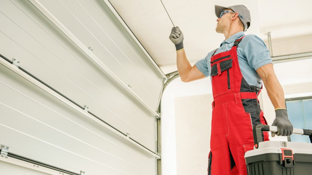 A garage door repair technician working on a residential door