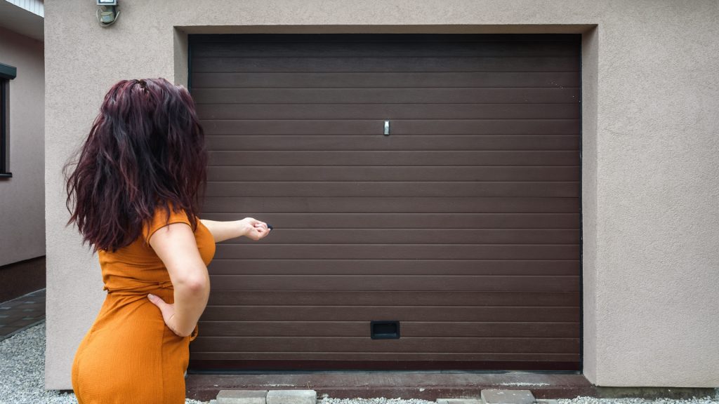 A homeowner testing their door for garage door opener problems