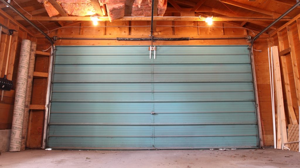 An old door that needs professional garage door installation for replacement