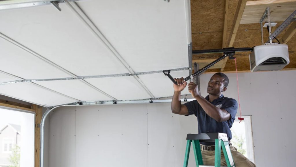 A professional technician performing garage door opener installation