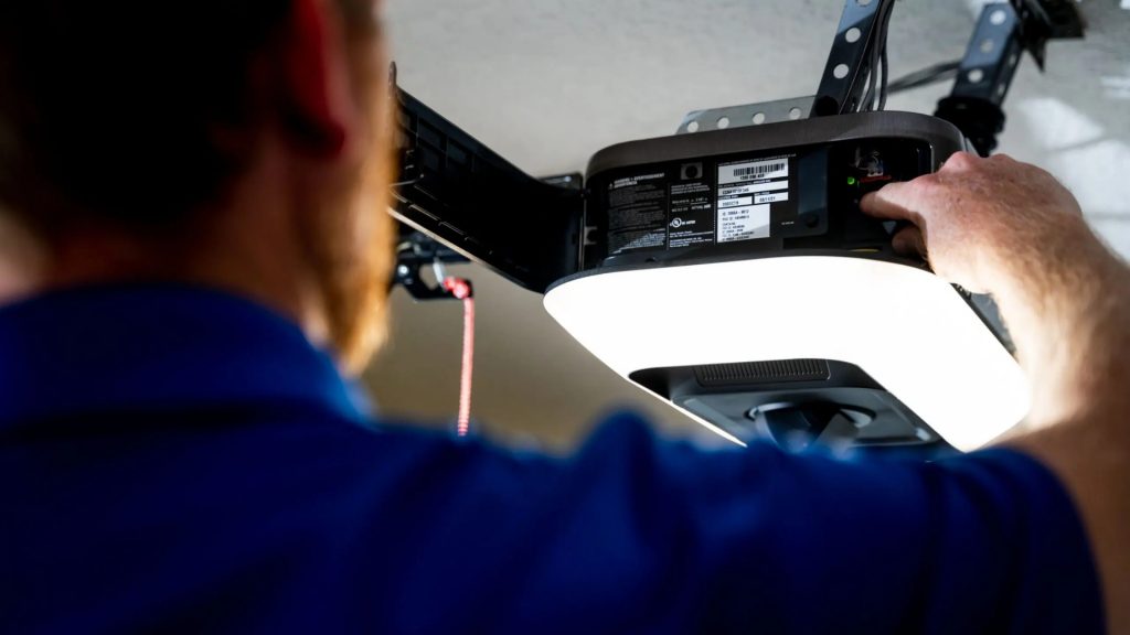 A technician setting up a LiftMaster unit with garage door battery backup
