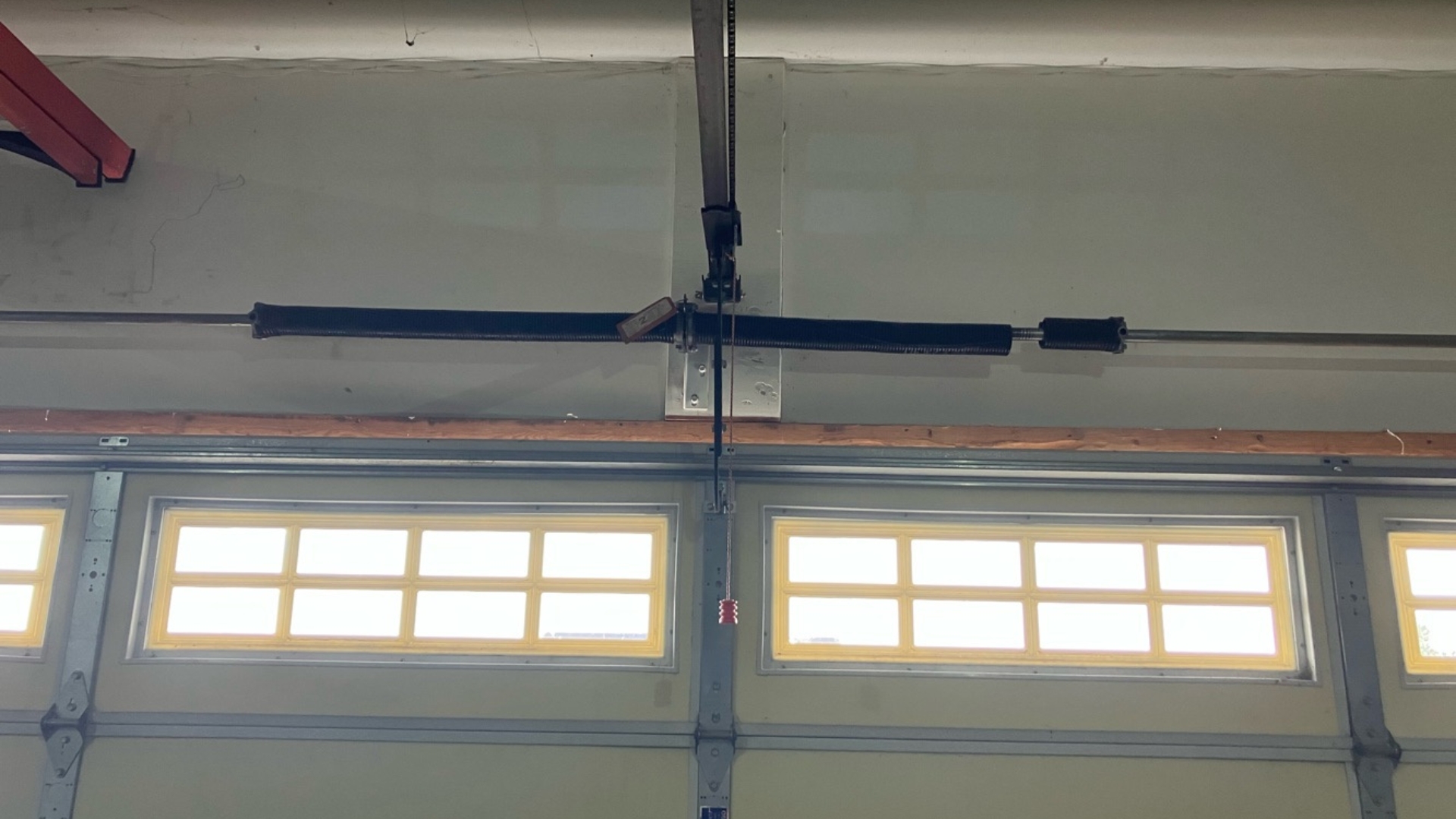 A torsion garage door spring installed at the top of the system