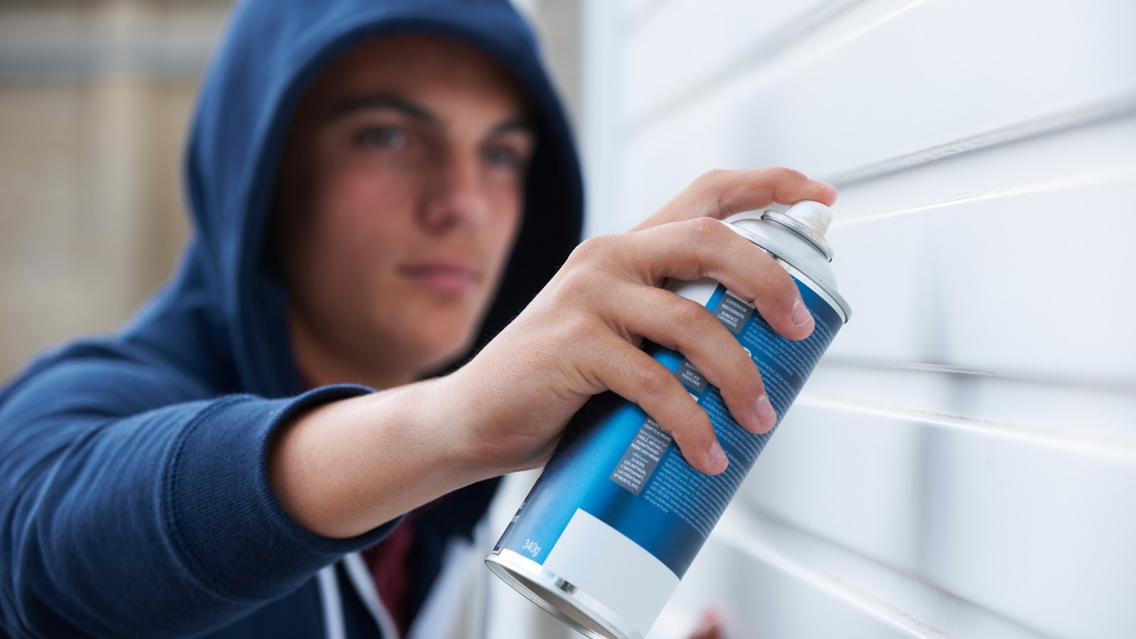 A man spraying a protective coat to prevent garage door rust to form