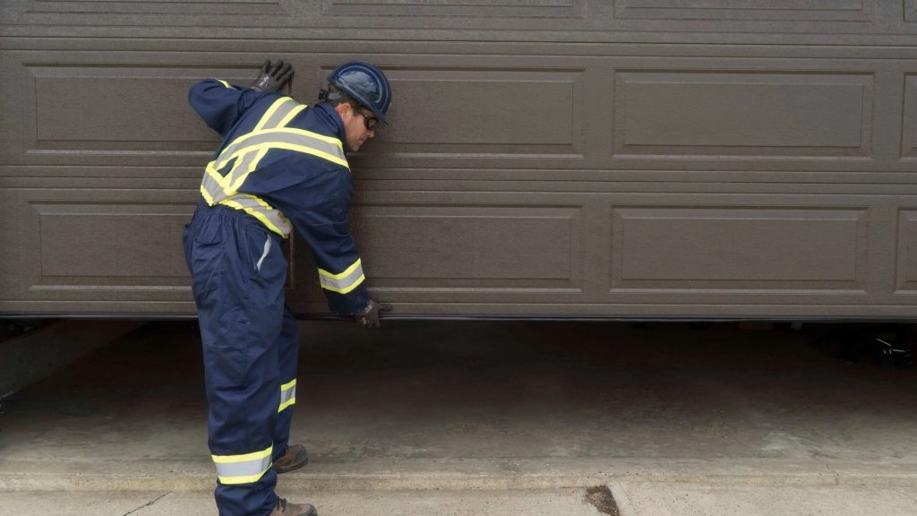 A garage door technician opening the garage door manually