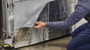 A man installing garage door insulation