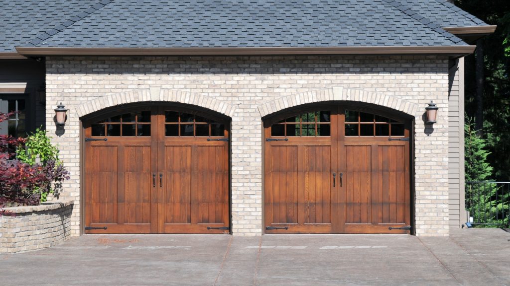 New garage door installation with wood panels and glass windows